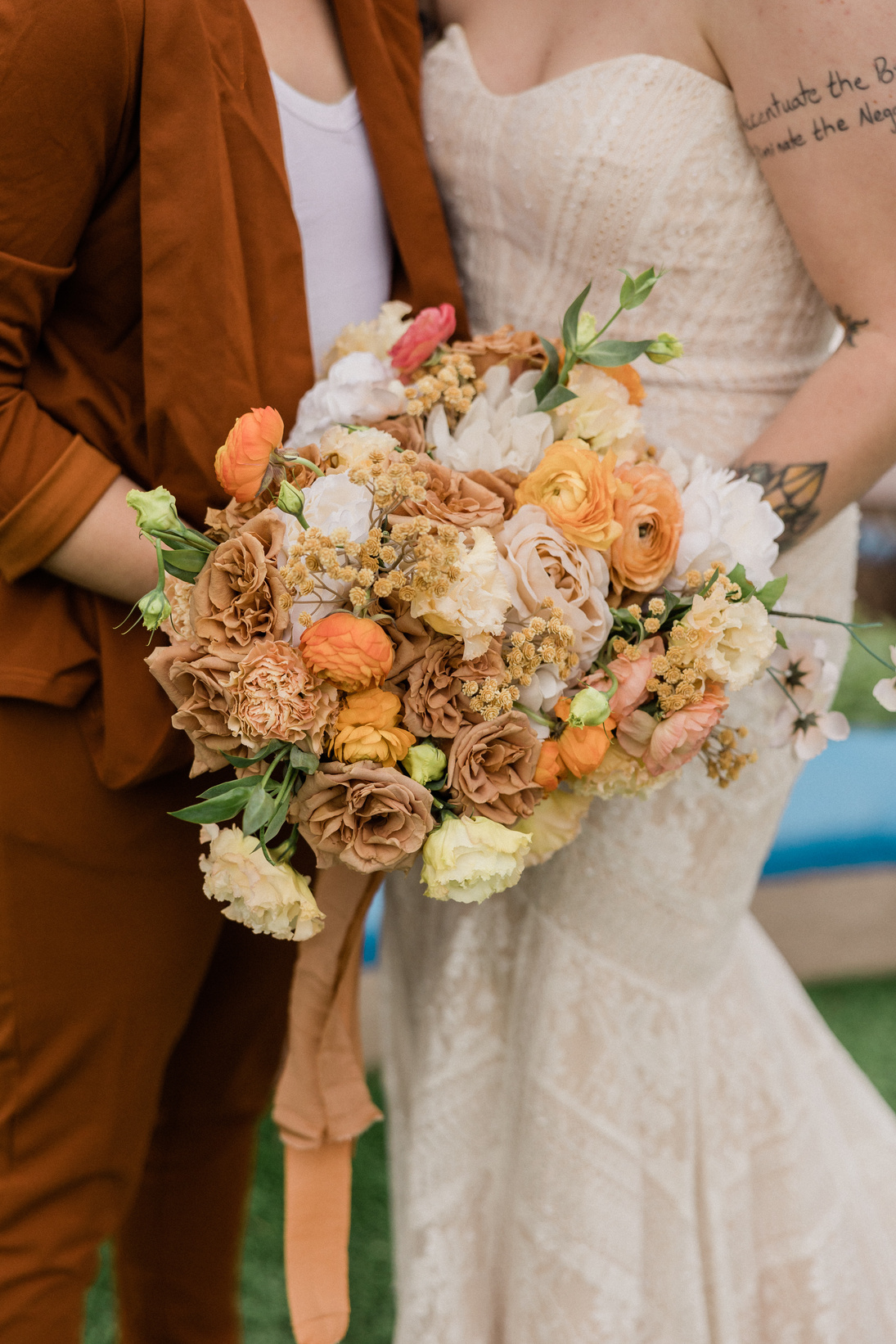 Newlywed Couple with Bridal Bouquets Posing Outdoors